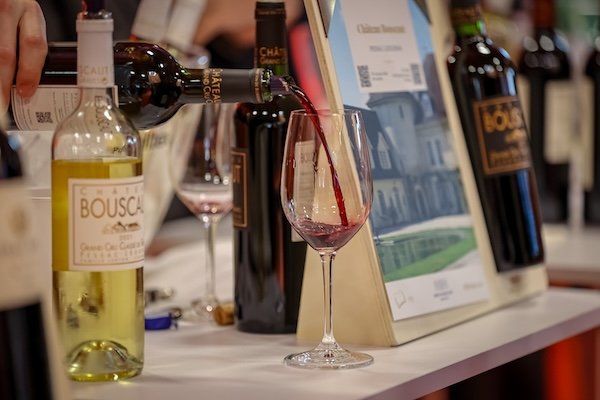 Wine vendor pouring red wine from a bottle into a wine glass