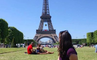 Woman picnicking on the grass of the Champ de Mars in front of the Eiffel Tower in Paris